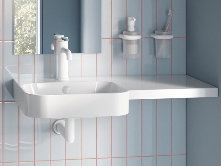 Accessible toilet with a wall-mounted WC, a hinged support rail and a washbasin with a mirrored cabinet in the bathroom