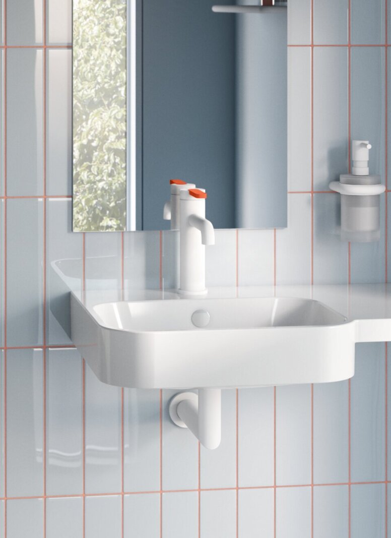 WC with a hinged support rail on the side and a support rail behind the WC in a bathroom with high levels of accessibility and a compact washbasin