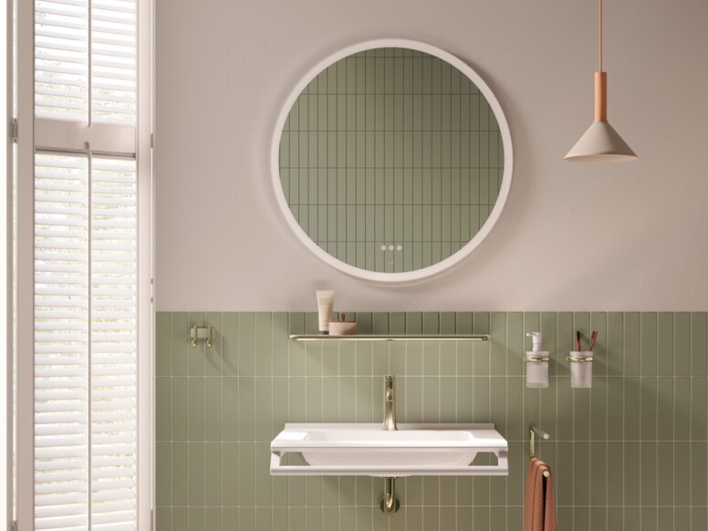 HEWI Range 480 PVD Interior An accessible washbasin with a front-mounted support rail and a stool against a green tiled wall