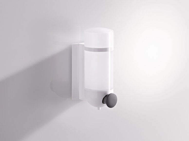 HEWI System 800K Soap Dispenser Synthetic material soap dispenser with a transparent container and a round pump in white and grey against a white wall