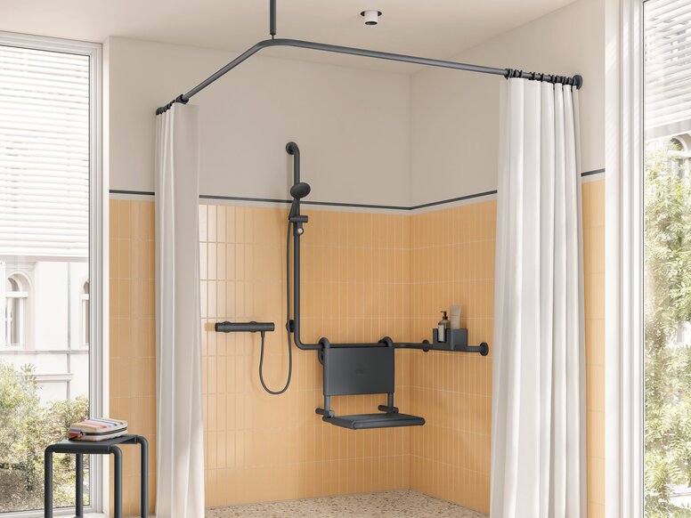 A hinged seat with a backrest and side support rails, including a handrail for the shower head in the yellow shower area, with a stool next to it