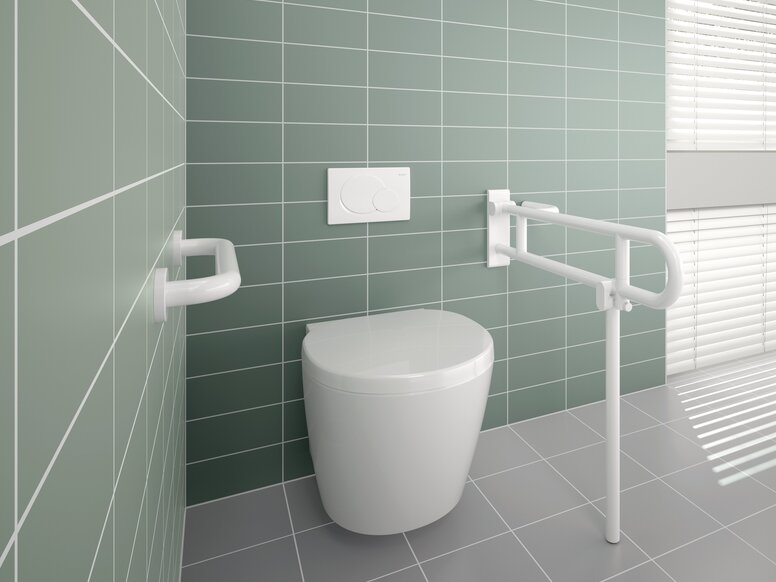 A white hinged support rail and grab rail fitted next to a white WC against a light green tiled wall