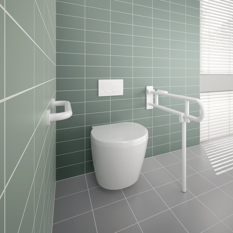 A white hinged support rail and grab rail fitted next to a white WC against a light green tiled wall