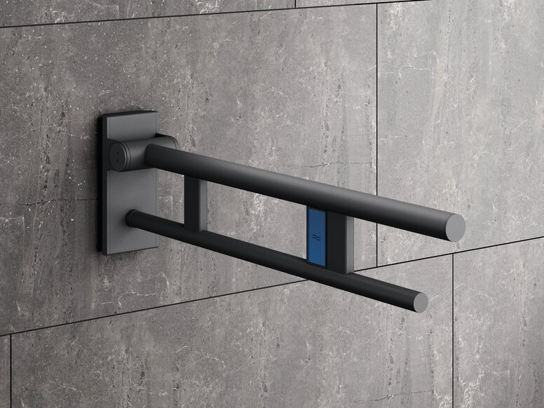 A dark grey powder-coated support handle with two parallel bars and a blue push button, set against a background of grey stone tiles