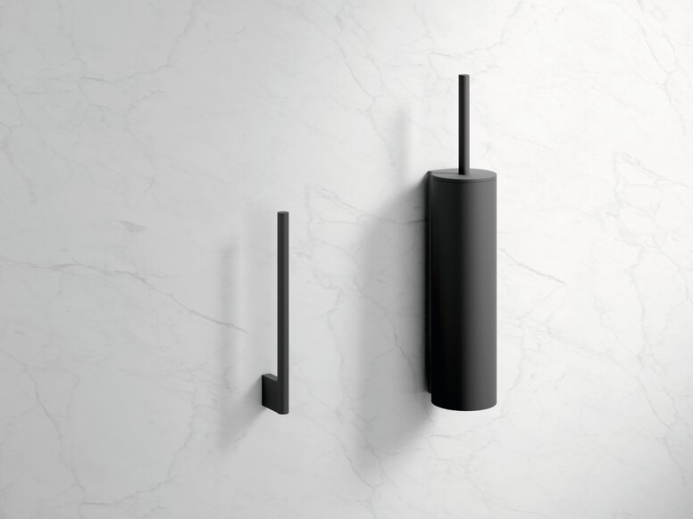 Black powder-coated toilet roll holder and black toilet brush holder on a white marble wall