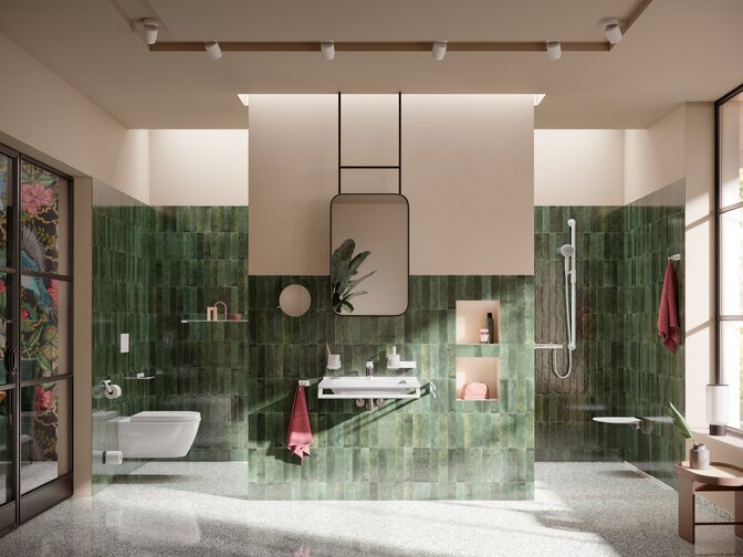 Accessible washbasin with tap, wall-hung WC and accessible shower area with a hinged seat against a green tiled wall