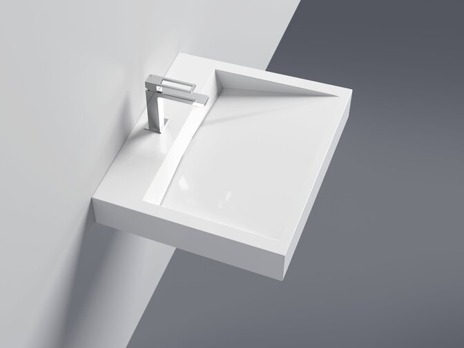 A white, wall-mounted washbasin made of mineral composite with a square shape and a tap on a white wall, with a grey floor beneath it