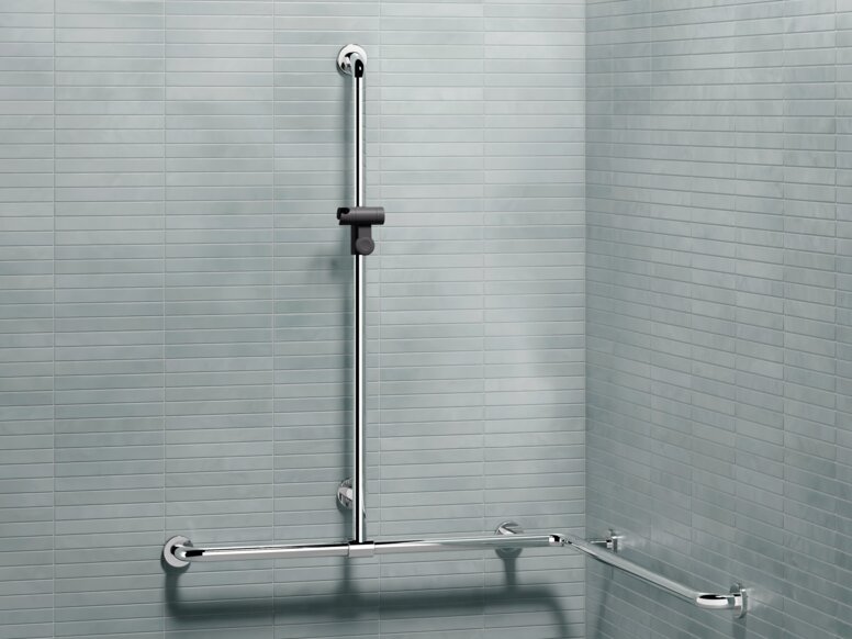 HEWI WARM TOUCH Duschhandlauf mit verschiebbarer Brausehalterstange Haltegriff in L-Form mit senkrechtem Brausehandlauf und Duschkopfhalter an gefliester Wand im Duschbereich