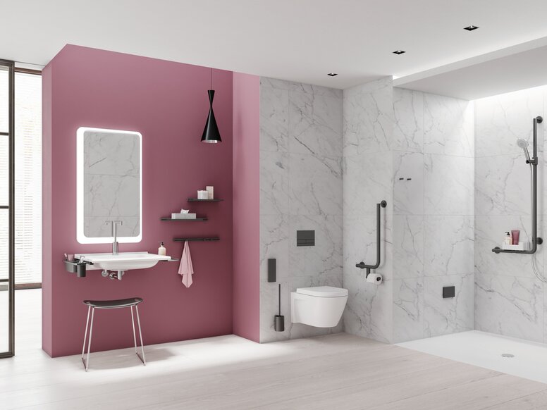 Modern bathroom with a pink wall behind the washbasin, illuminated mirror, wall-hung toilet and level-access shower with white and grey marble-effect tiles, complemented by black grab rails and fittings