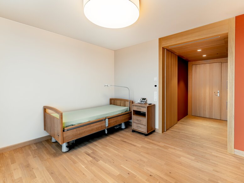 Schlafzimmer im Haslibrunnen in der Schweiz Pflegebett mit Nachttisch im Schlafzimmer